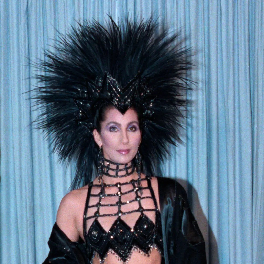 Bob Mackie criou roupas deslumbrantes com penas e pedrarias, como as usadas no Oscar em 1986. A ousadia desse tipo de f…