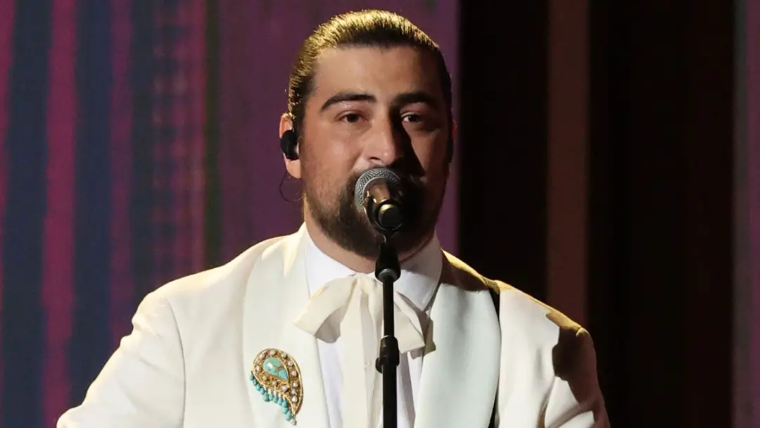 Noah Kahan cantou Bridge Over Troubled Water no Peacock Theater durante os Emmy Awards de 2026. Esse momento de homenag…