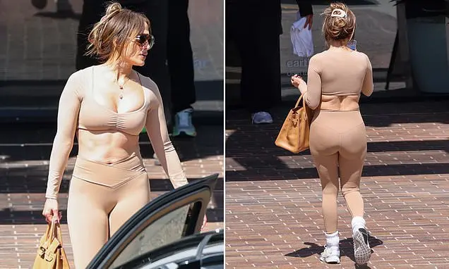 Jennifer Lopez, 57 anos, com um top cropped nude e legging, foi vista na academia com uma bolsa Birkin de 22 mil libras…
