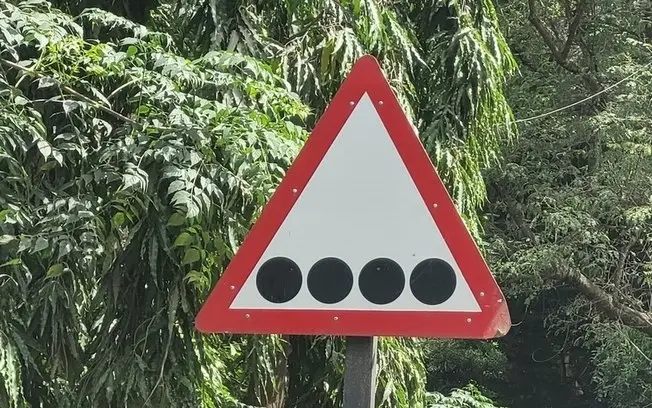 Bengaluru, Índia, viu uma placa de trânsito com quatro pontos pretos perto de escola para deficientes visuais. O aviso …