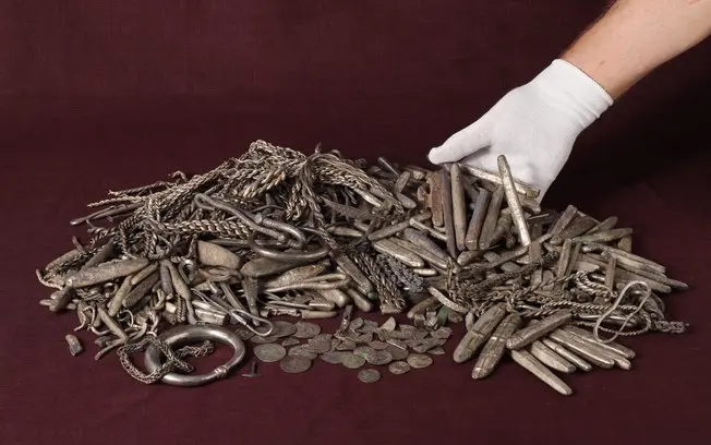 Um homem em Rebild, Dinamarca, achou um tesouro viking de quase 18,5 quilos com 700 objetos de prata. Isso mostra como …