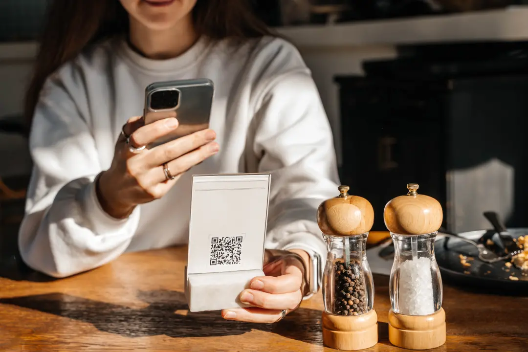 Cardápios físicos sendo trocados por QR Codes em restaurantes. O isolamento digital impede a conversa que a mesa compar…