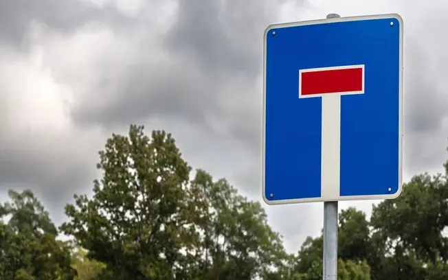 Placa de trânsito britânica de fundo azul gera confusão sobre se a via termina ou se é proibida. O manual brasileiro us…
