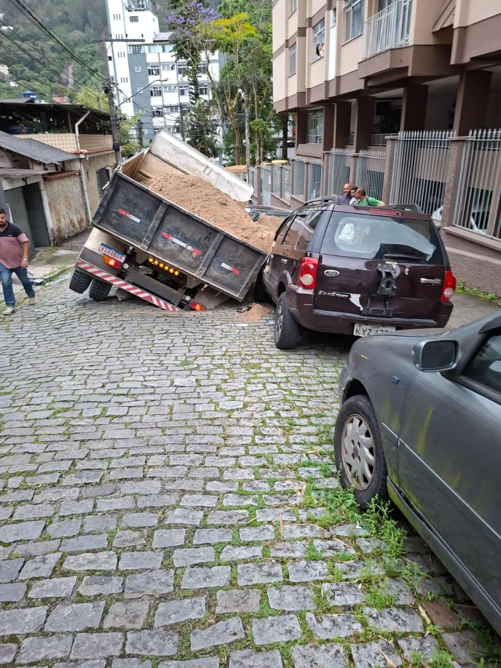 Galeria de esgoto cede em Nova Friburgo e engole caminhão, atingindo um carro estacionado na Rua Coronel Sarmento. O pr…