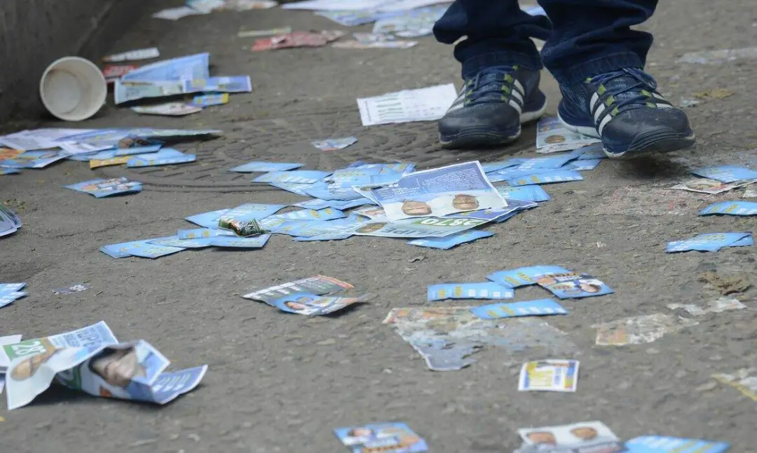 Duaszenas de Porto Alegre, 20 toneladas de santinhos foram recolhidas pelo DMLU depois da eleição. Esse acúmulo mostra …