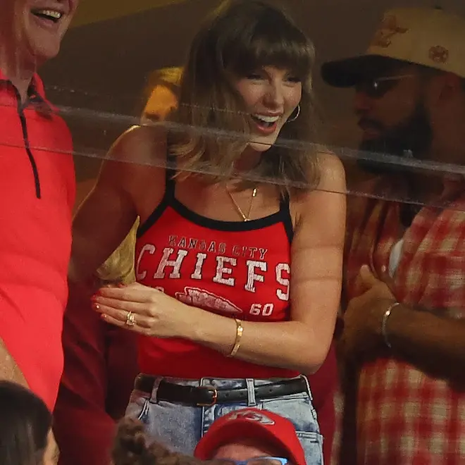 Taylor Swift no Arrowhead Stadium com look clássico de batom vermelho, como Travis Kelce gosta. Essa vibe de estilo não…