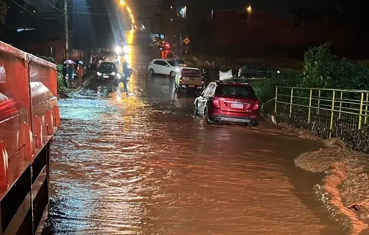 Idoso ilhado em Jataí após córrego transbordar durante chuva forte. A força da correnteza exige que os bombeiros usem c…