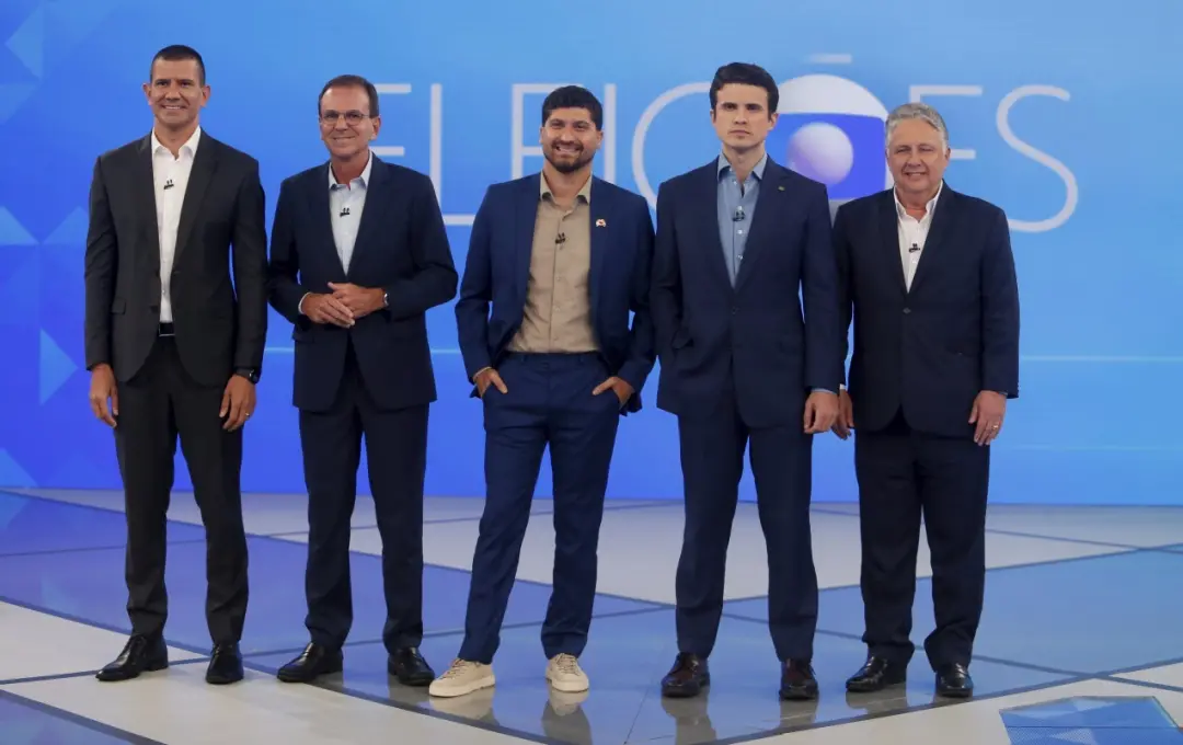 Dois ônibus com vidros estilhaçados na Maré foram atacados por criminosos, conforme André Marinho relatou em debate no …