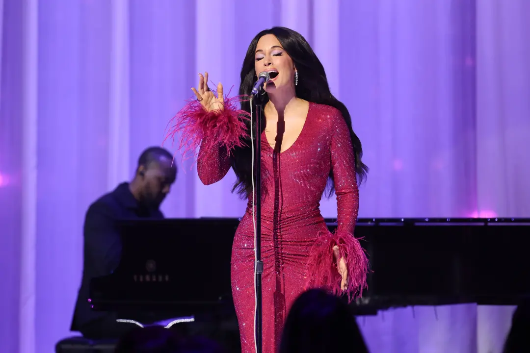Kacey Musgraves homenageou Dolly Parton na VMAs 2026 com um look de paetês rosa, penas e cabelo enorme. O visual seria …