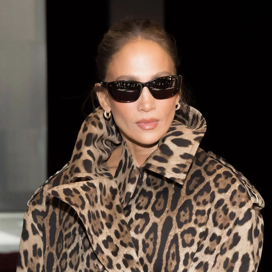Jennifer Lopez arrasou em Milão com saia mini de estampa de leopardo da Dolce & Gabbana e trench coat combinando. Goste…