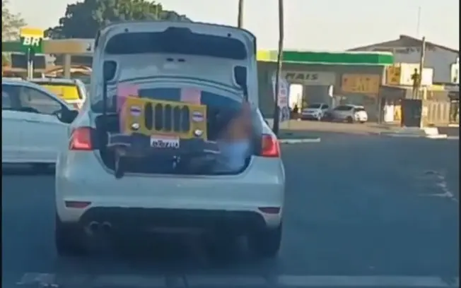 Em Inhumas, Goiás, uma criança foi filmada no porta-malas de carro em movimento para levar uma maquete de escola. A mãe…