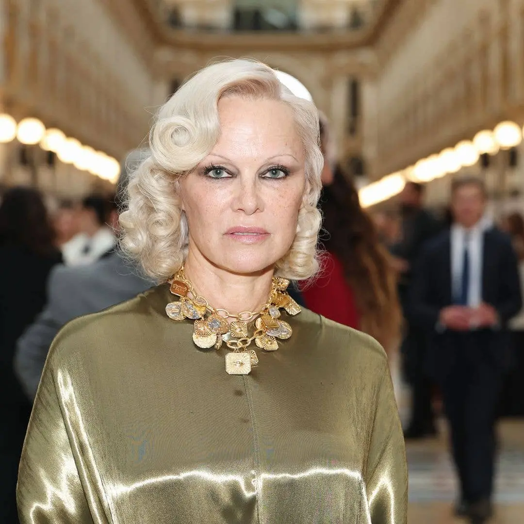 Pamela Anderson apareceu com maquiagem esfumada e vestido dourado Ferragamo na Vogue World em Milão no dia 22 de setemb…