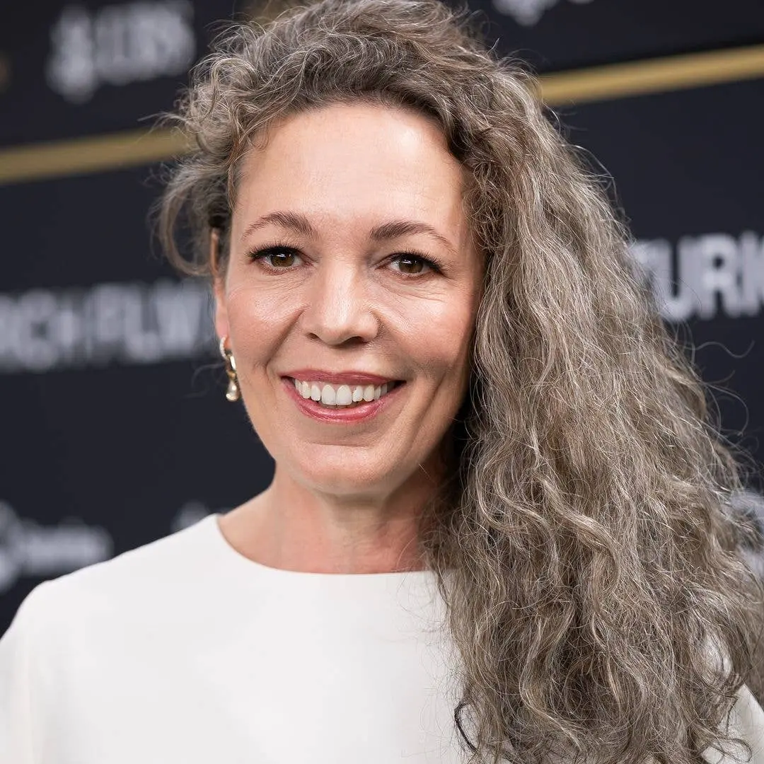 Olivia Colman com cabelo grisalho longo prova que cabelo grisalho depois dos 50 não é sinal de envelhecimento. É um exe…