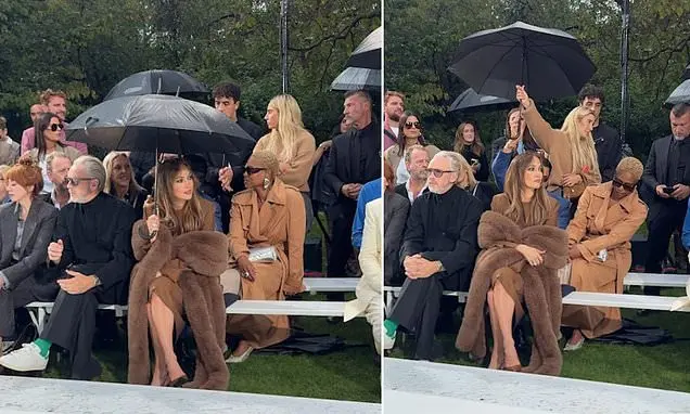 Jennifer Lopez irritada com a pedido de staff para abaixar o guarda-chuva no desfile da Stella McCartney em Paris. Pond…