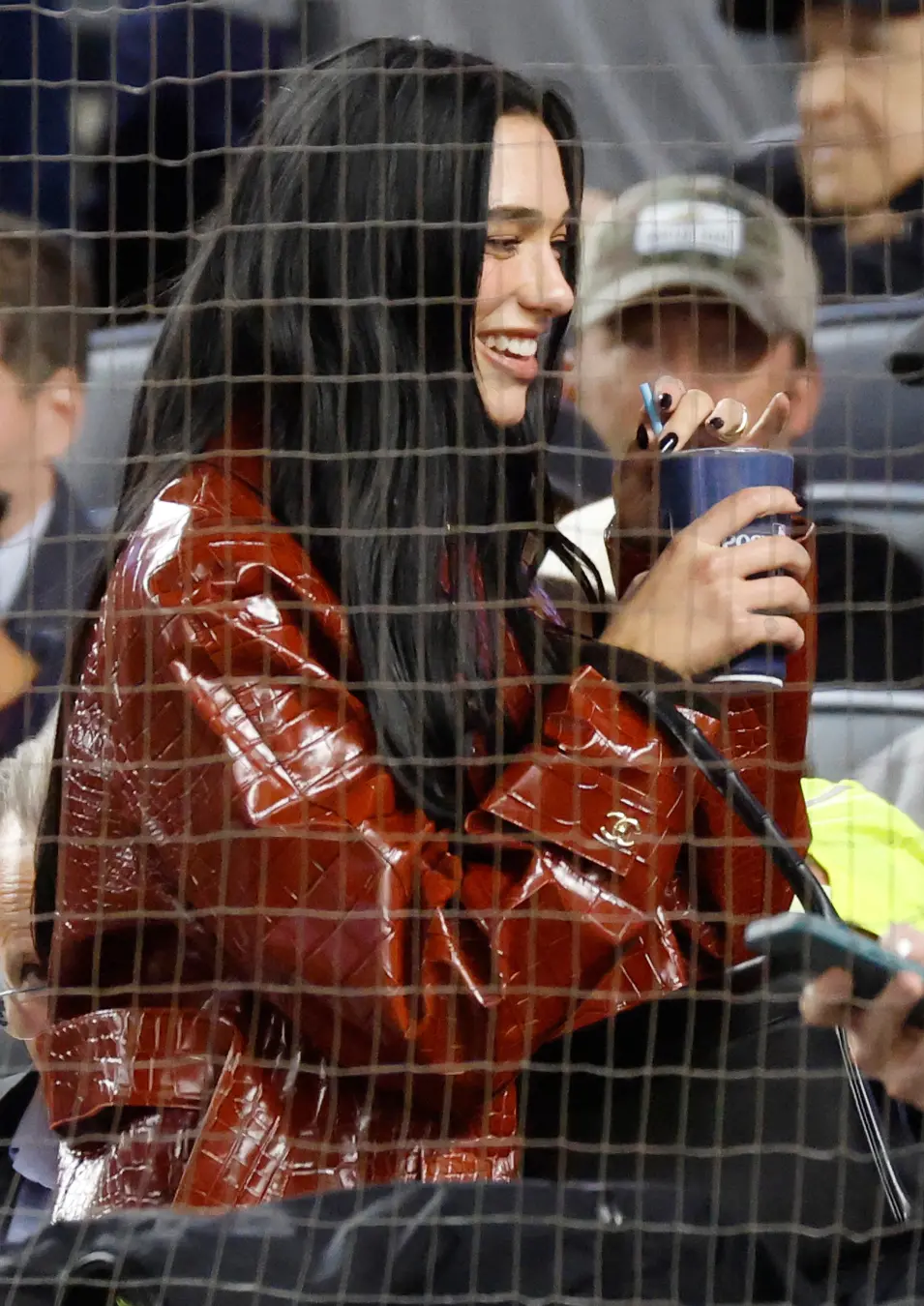 Dua Lipa levou um casaco Chanel de 15 mil dólares para um jogo dos Yankees. Essa mistura de luxo em evento esportivo mo…