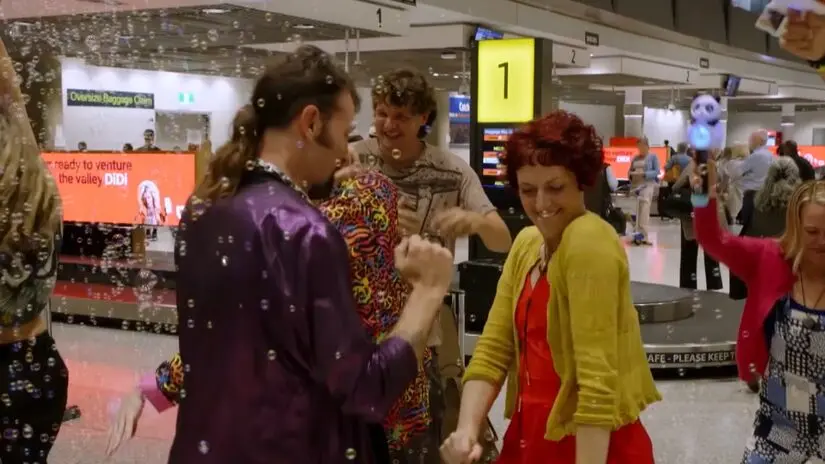Nigel surpreende Andi com um flash mob no aeroporto da Austrália para recebê-la. A ideia dele foi uma festa na chegada,…